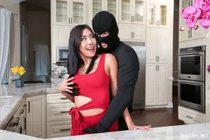 Cô gái mới với mái tóc dài và đôi môi đỏ cởi cúc áo ngủ, tạo dáng và dang rộng âm hộ, xoa bóp nó
